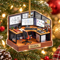 Design Build Iterate ornament hanging on a Christmas tree featuring a miniature office cubicle with dual monitors and name