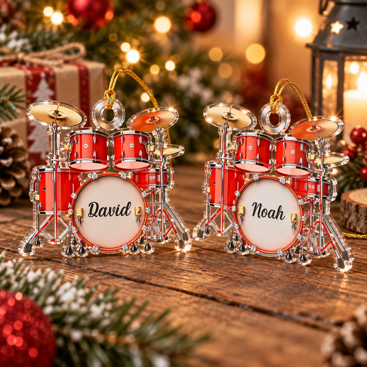 Two personalized drum set Christmas ornaments standing on a wooden table with holiday decor, one with the name David and one