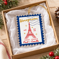 Honeymoon travel ornament inside an open gift box with tissue paper.