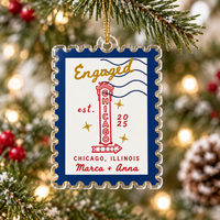 Personalized acrylic stamp ornament with navy border, Chicago theme, and 'Engaged' text hanging on a Christmas tree.