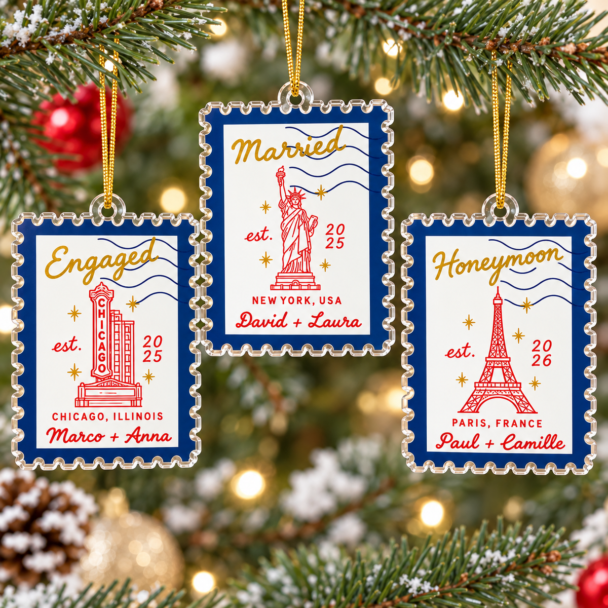 Three custom acrylic postage stamp ornaments hanging on Christmas tree branches.