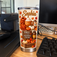 Personalized stainless steel tumbler featuring seasonal autumn designs standing near a computer keyboard.