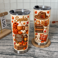 Two custom name hello fall tumblers with autumn graphics stand on a textured surface next to a calendar.