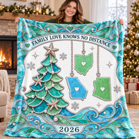 Woman smiles while holding up the family bond reminder blanket in front of a stone fireplace and Christmas tree.