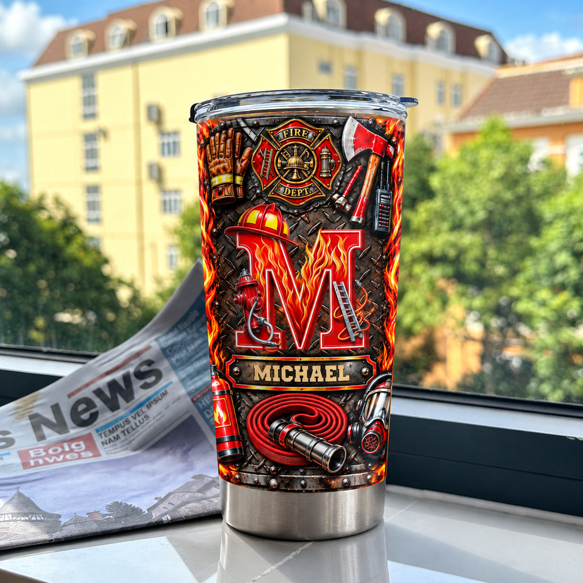Personalized firefighter stainless steel tumbler next to a folded newspaper on a windowsill.