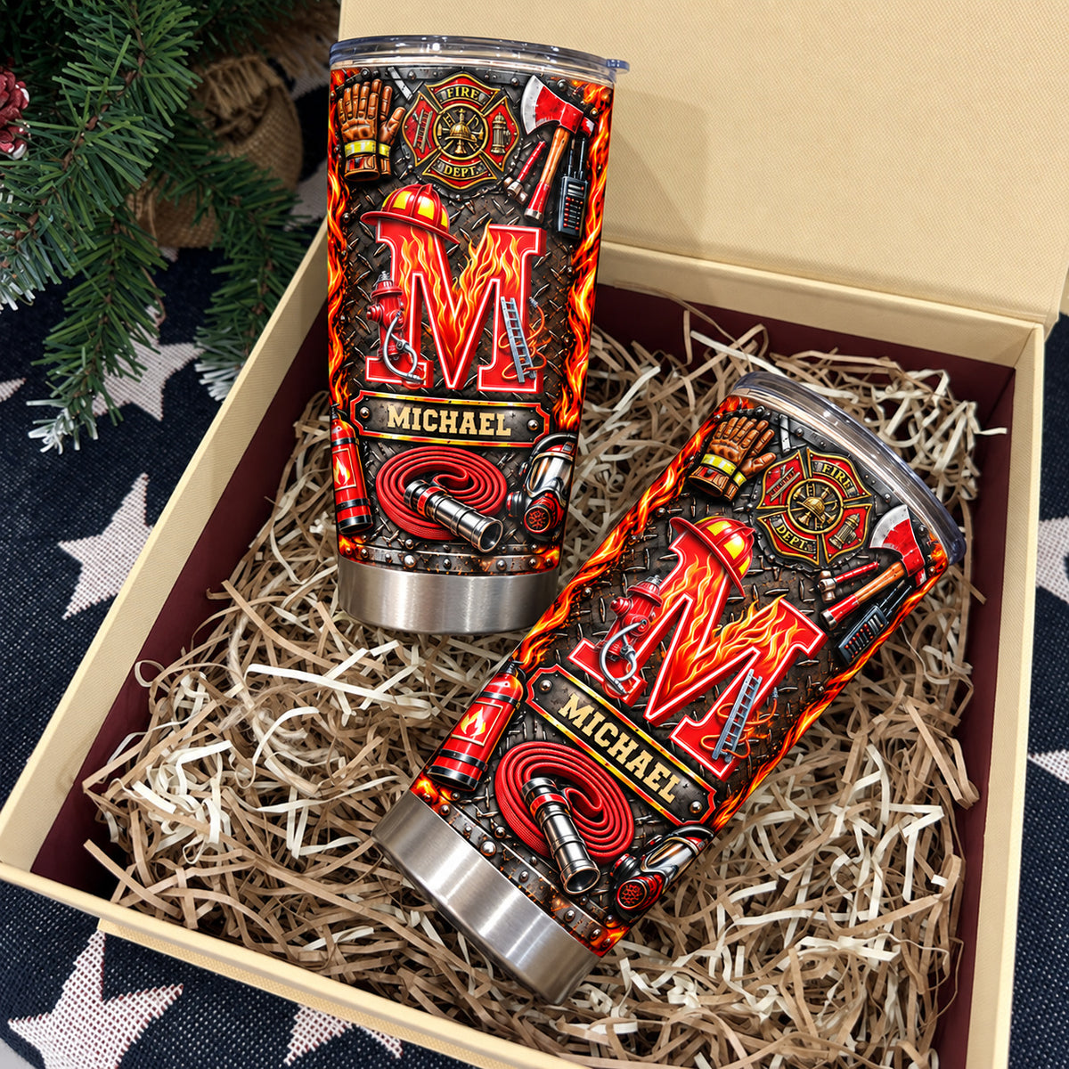 Two personalized firefighter initial name tumblers nestled inside an open gift box with shred paper.