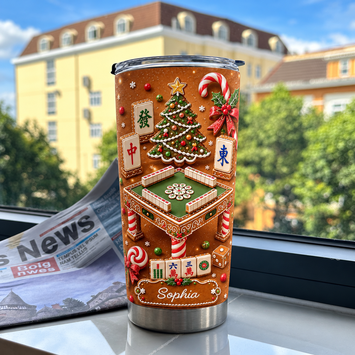 A personalized mahjong gift tumbler standing on a windowsill with a newspaper against a building backdrop.