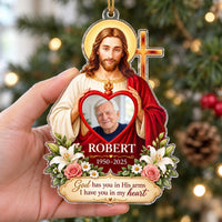 Personalized clear acrylic memorial ornament featuring Jesus holding a heart frame with a photo, white lilies, and text.