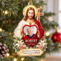Christian memorial ornament hanging on a Christmas tree with Jesus holding a red heart photo frame of an older man.