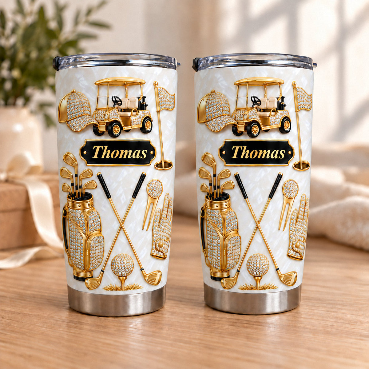 Two personalized golf tumblers with gold rhinestone graphics, a black nameplate reading Thomas, and a golf cart design on a
