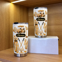 Two golf tumblers of different sizes displayed on a white box inside a wooden cabinet.