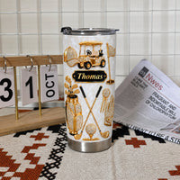 Personalized golf tumbler with gold rhinestone graphics of a cart, clubs, and the name Thomas, standing on a patterned mat.