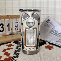 Stainless steel insulated golf mug featuring a scorecard clipboard design, set indoors near a calendar.