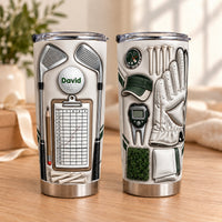 Two beige stainless steel tumblers showing golf gear print with crossed irons, scorecard, golf ball reading David, glove, and