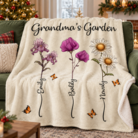 A custom name blanket draped over a green sofa with watercolor purple irises and white daisies.