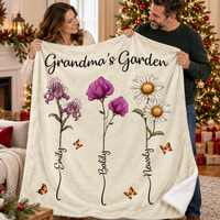 A smiling couple holds up a cream-colored custom sherpa blanket featuring Grandma's Garden text, watercolor floral stems, and