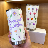 A hand holding a custom Grandma's Garden tumbler in front of a wooden shelf.