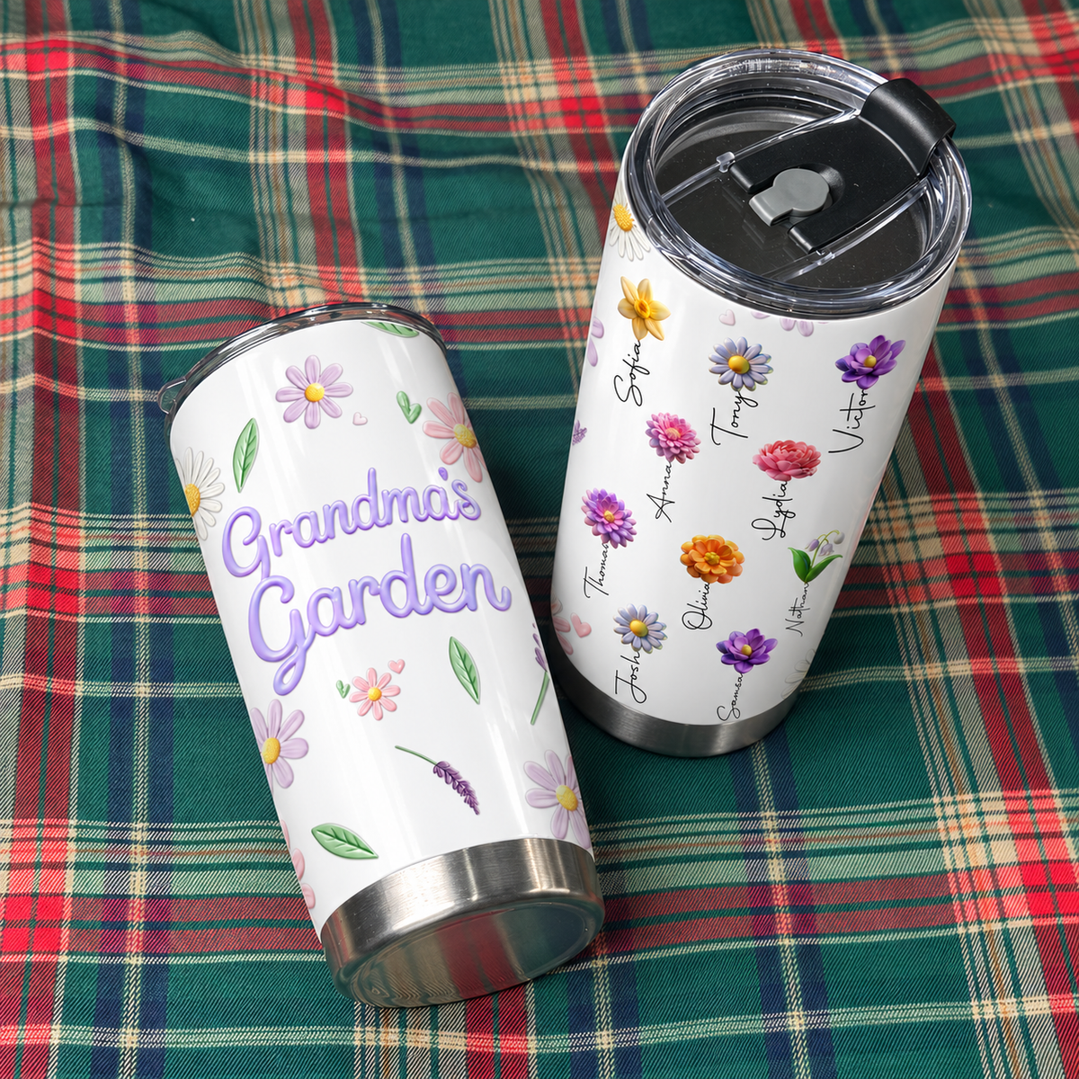 Two personalized insulated tumblers resting on a green and red plaid fabric surface.