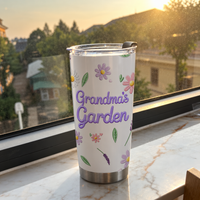 A single Grandma's Garden stainless steel tumbler on a marble windowsill at sunset.
