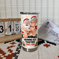 Funny Santa tumbler standing on woven fabric next to desk calendar and newspaper in indoor setting.