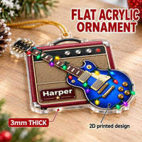 A flat blue guitar amp acrylic ornament resting on a wooden surface with a label indicating thickness and print style.