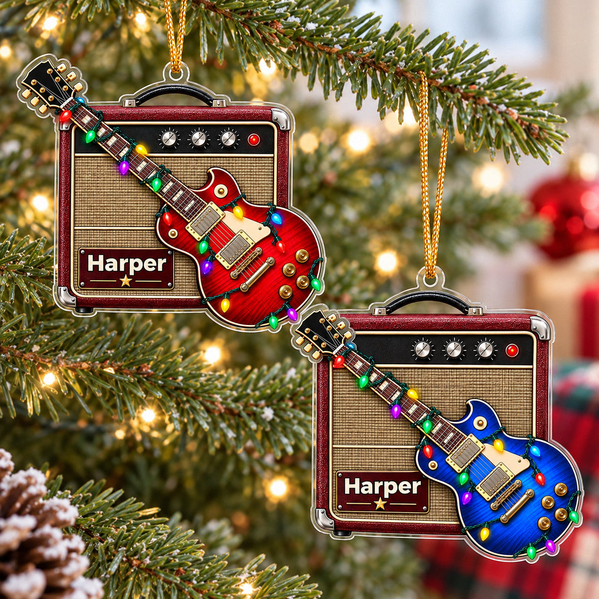 Two personalized guitar amp acrylic Christmas ornaments hanging on a pine tree with warm lights, featuring red and blue