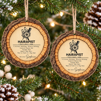 Pair of personalized wood ornaments hanging on Christmas tree branches with twinkling lights.