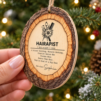 Close-up of a hand holding the flat round custom name wood ornament with jute twine.