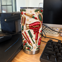 A stainless steel hairdresser tumbler with red styling tool prints sits on a desk next to a keyboard, mouse, and computer