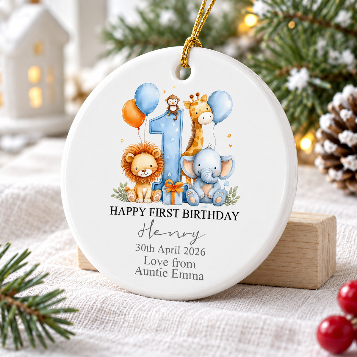 Custom safari animal keepsake ornament displayed upright on a wooden block next to a miniature white house and pinecone.