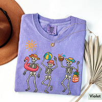 Violet purple t-shirt displaying a colorful retro skeleton summer design, folded flat.