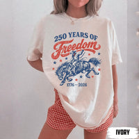 A woman wearing an oversized ivory t-shirt with a patriotic cowboy and bucking horse graphic.