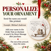 Personalized round white ceramic memorial ornament hanging by red ribbon with pebble angels, cardinal, and custom name.