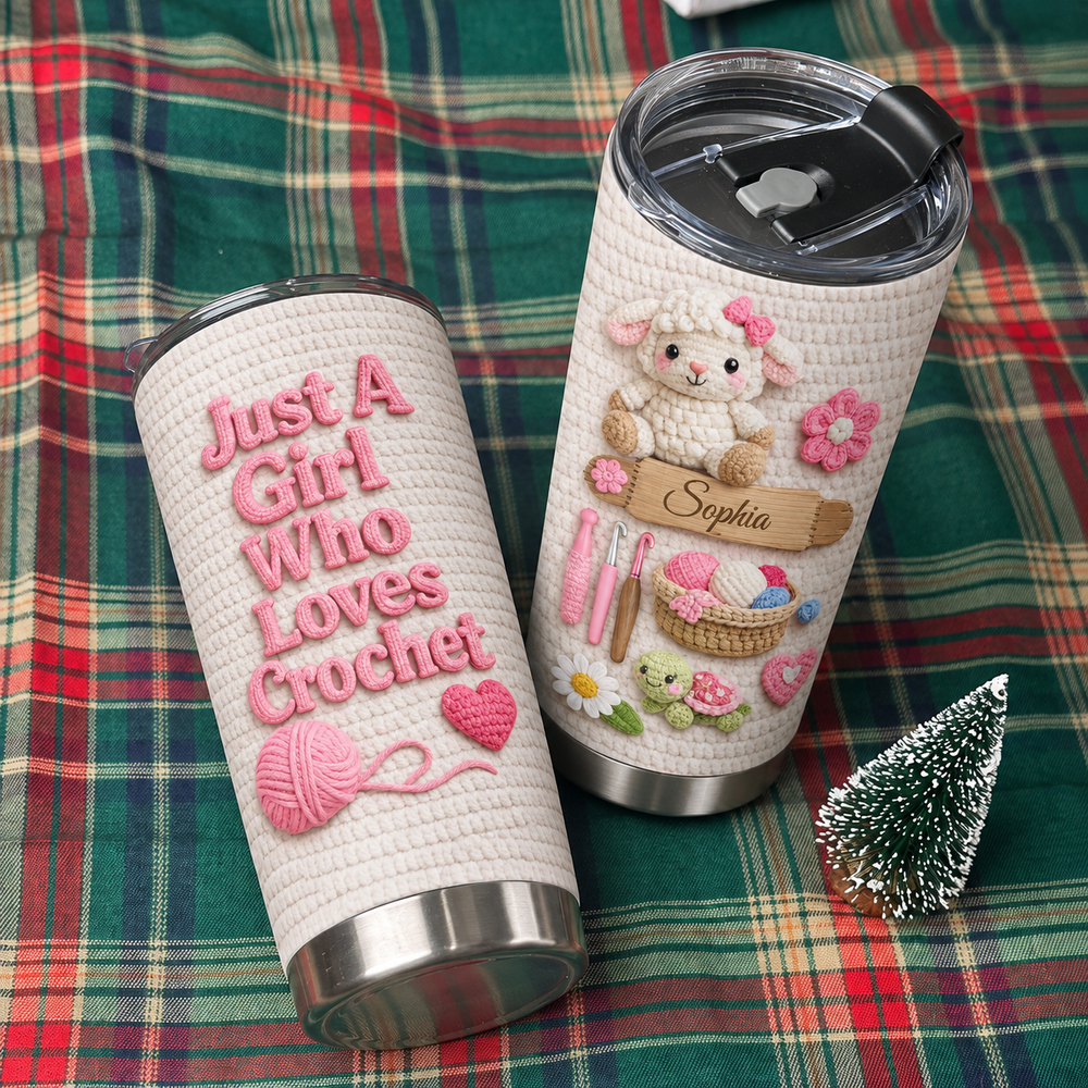 Personalized insulated stainless steel cup on green plaid fabric next to miniature Christmas tree, showing crochet graphics.