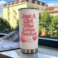 Personalized insulated stainless steel cup on windowsill overlooking city buildings, featuring cute crochet pattern and yarn.
