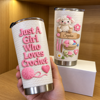 Hand holding personalized insulated stainless steel cup with pink crochet lettering and cream faux-crochet textured