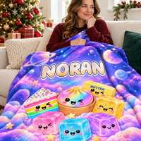 Galaxy print personalized blanket with cute dessert characters and the name Noran draped on a couch.