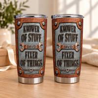 Two stainless steel tumblers with custom mechanic text stand upright on a wooden table with soft indoor lighting.