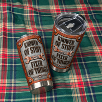 Two personalized dad tumblers rest diagonally on a green and red plaid fabric background.
