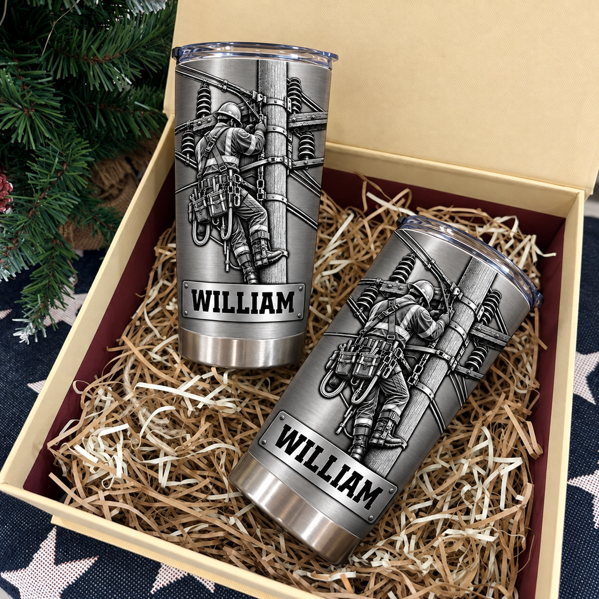 Two personalized lineman tumbler utility worker cups nestled inside a gift box filled with paper shred.