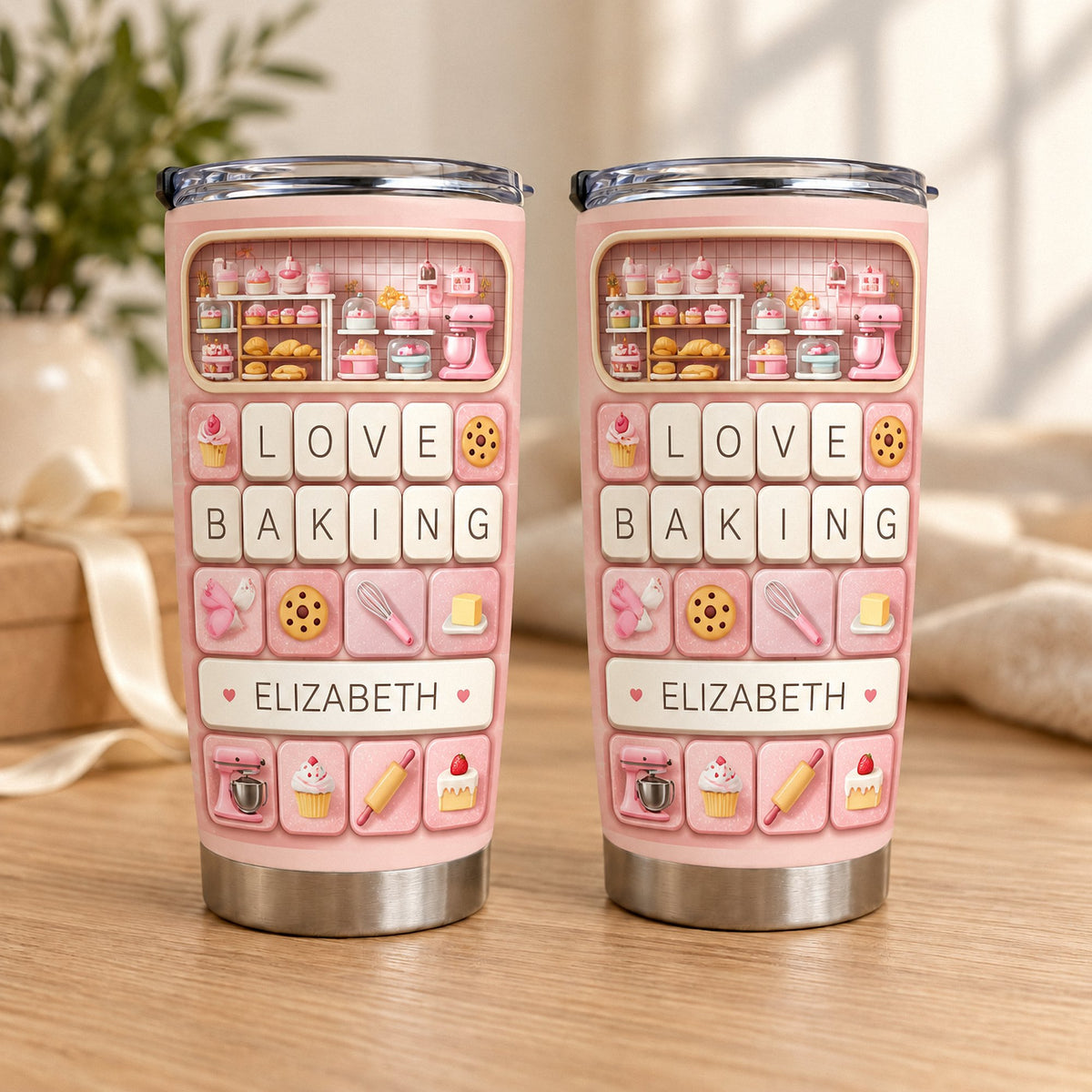 Two identical Love Baking Tumbler Personalized cups standing side by side on a wooden surface near a window.