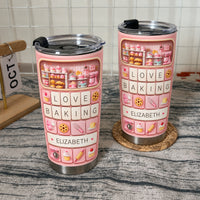 Two custom name tumblers in pastel pink displayed on a textured countertop with a calendar block in the background.