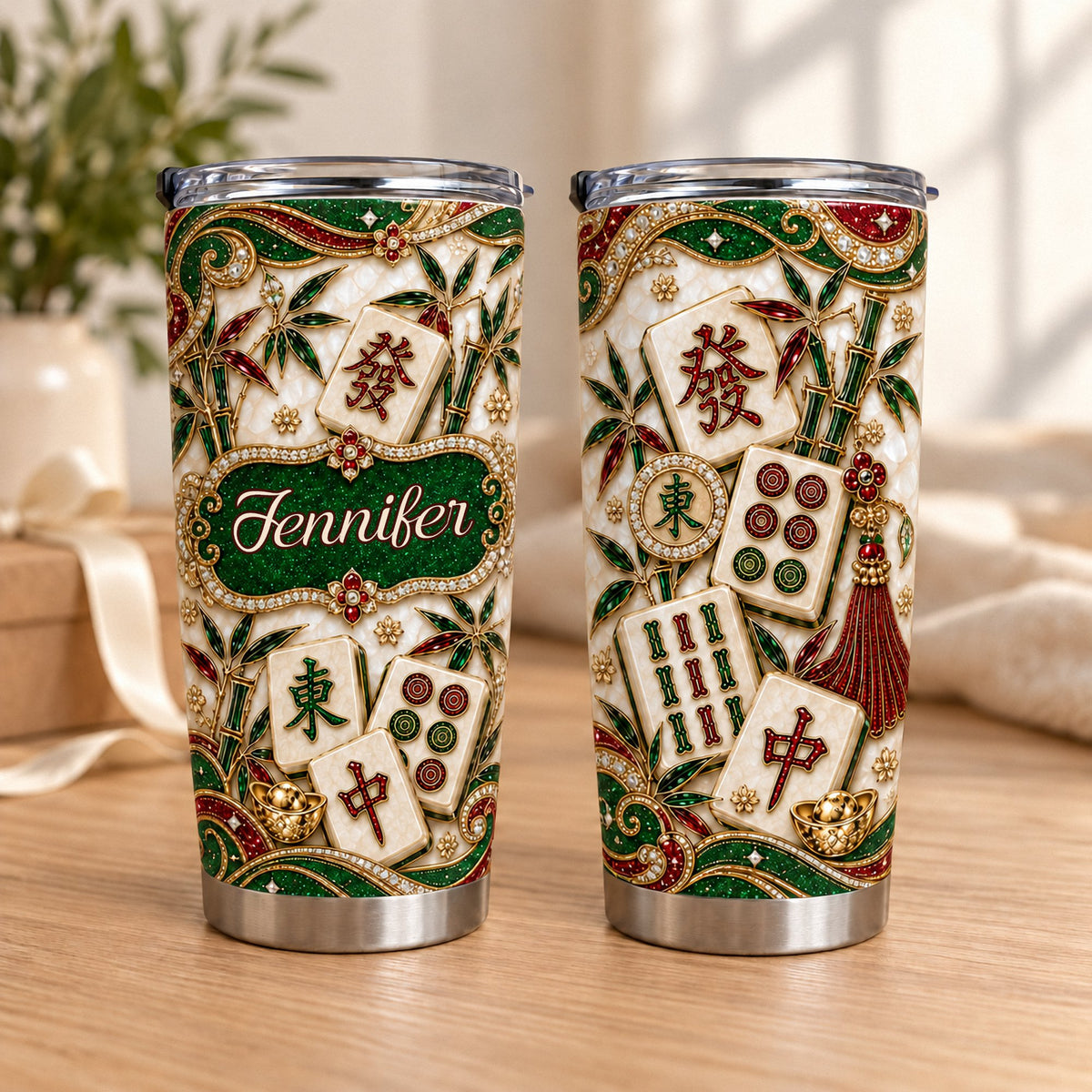 Two luxury mahjong tumblers displaying jewel-toned print with traditional tiles and custom name on wooden table.