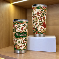 Two custom stainless steel tumblers with jeweled mahjong tile design standing on wooden shelf beside white box.