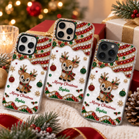 Three personalized Merry Christmas phone cases with rhinestone reindeer art displayed on holiday gift boxes.