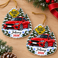 Two flat acrylic new driver ornaments featuring a red car graphic, snow-covered pine trees, and Johnny 2026 text on a wood
