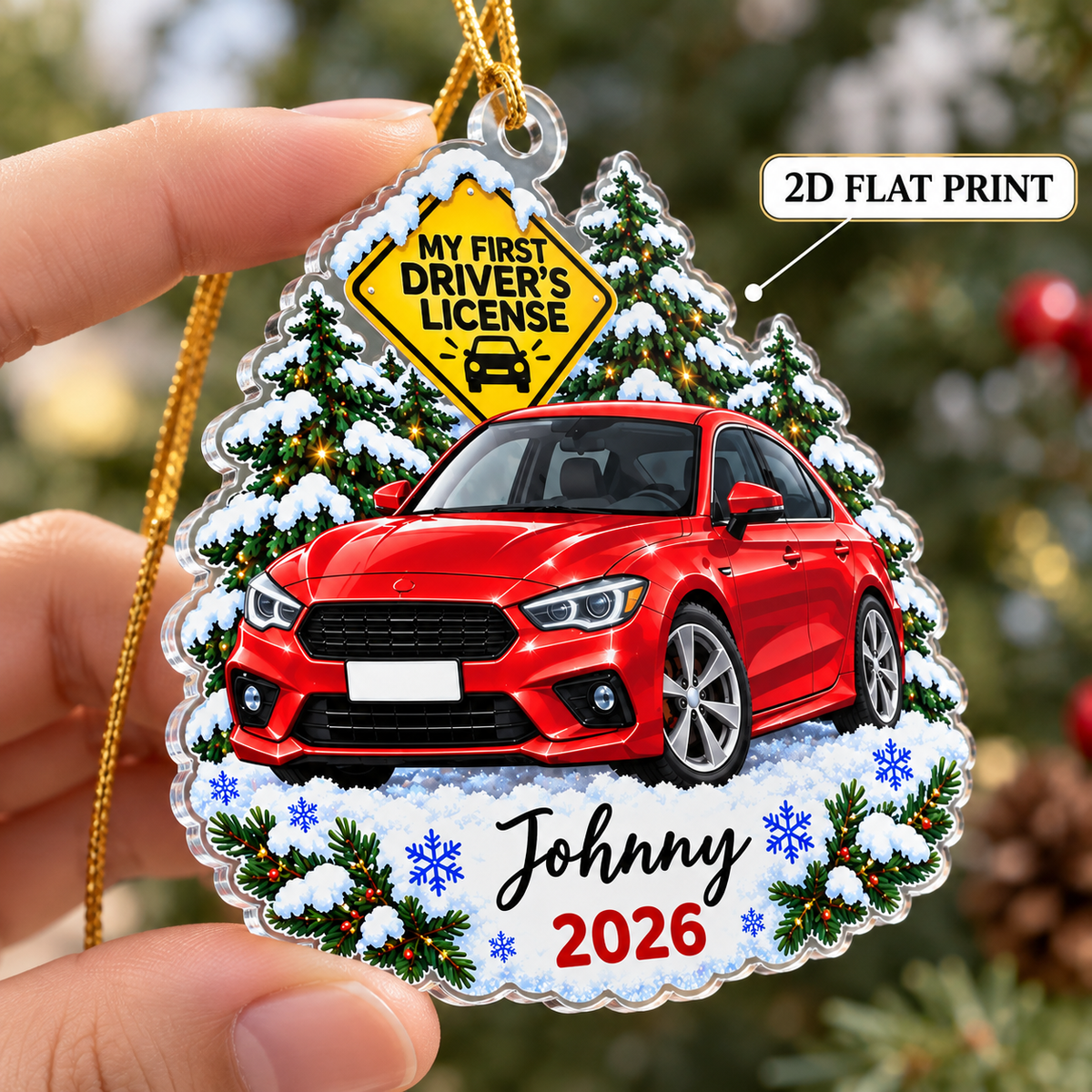 Hand holding a flat 2D printed acrylic Christmas ornament featuring a red car graphic, snow trees, and Johnny 2026 custom