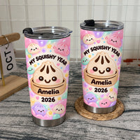 Two kawaii bao bun cups with pastel pink and mint green bubbles standing on a woven coaster and table.