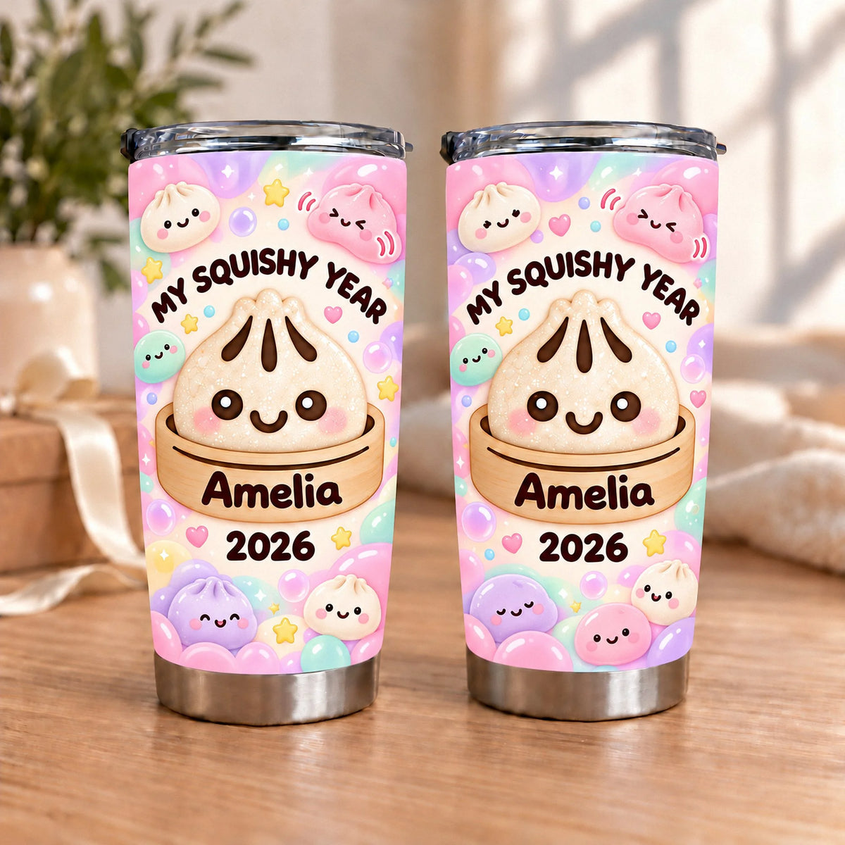 Two My Squishy Year tumblers with kawaii bao bun design, custom name Amelia and year 2026 on a wooden surface.