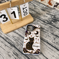 Personalized black cat phone case with white textured background placed next to a wooden desk calendar.